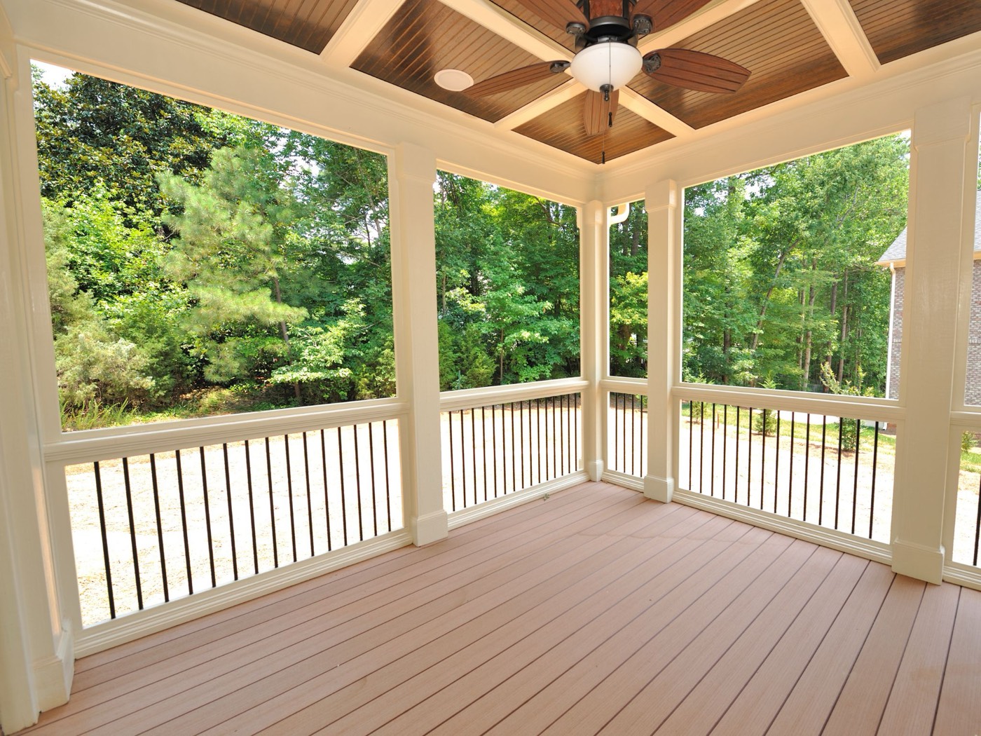 Vinyl deck built alongside a backyard fence